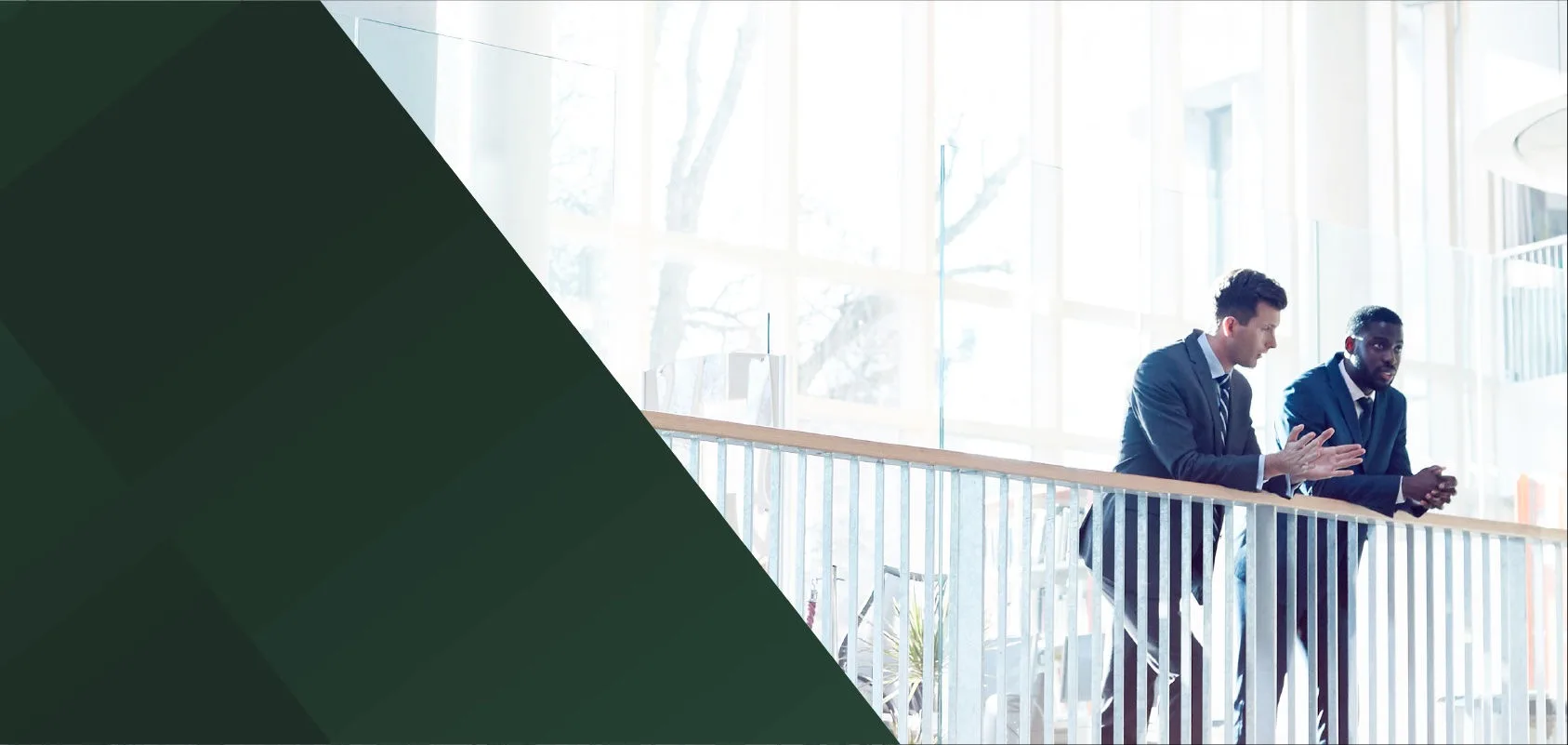 Two businessmen chatting at a balcony railing