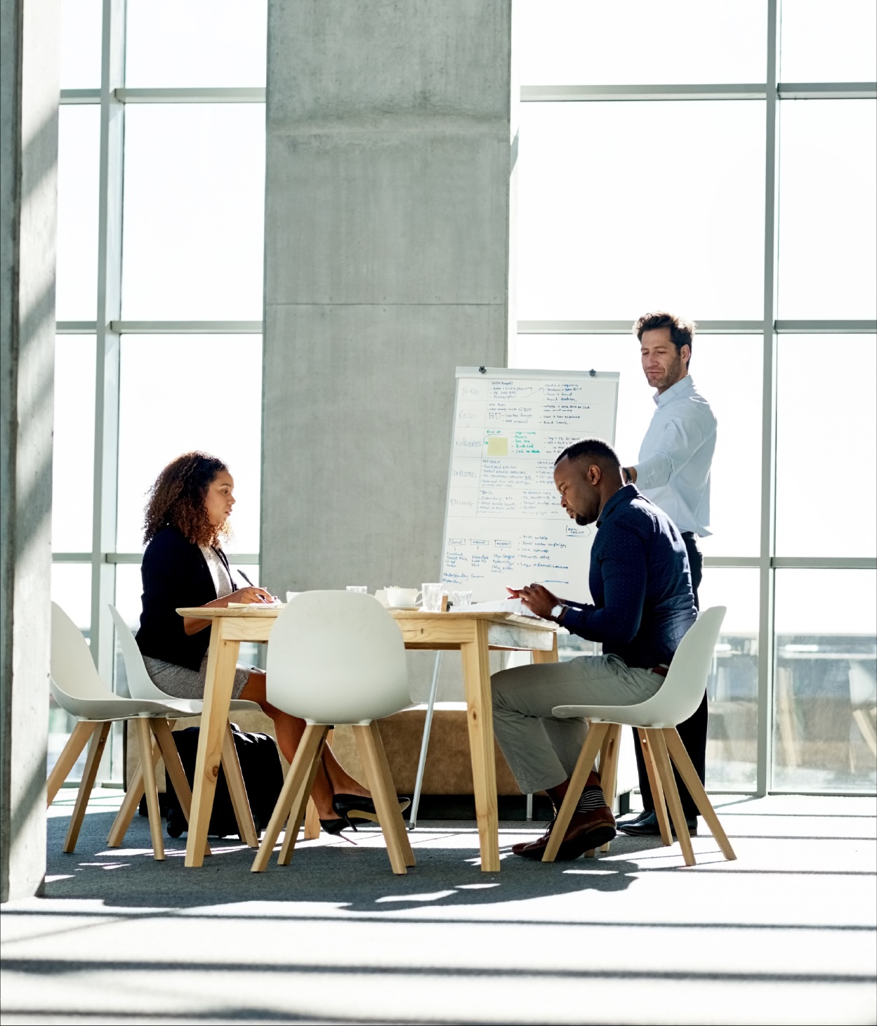 A small team discuss a project during a meeting in an open office environment.